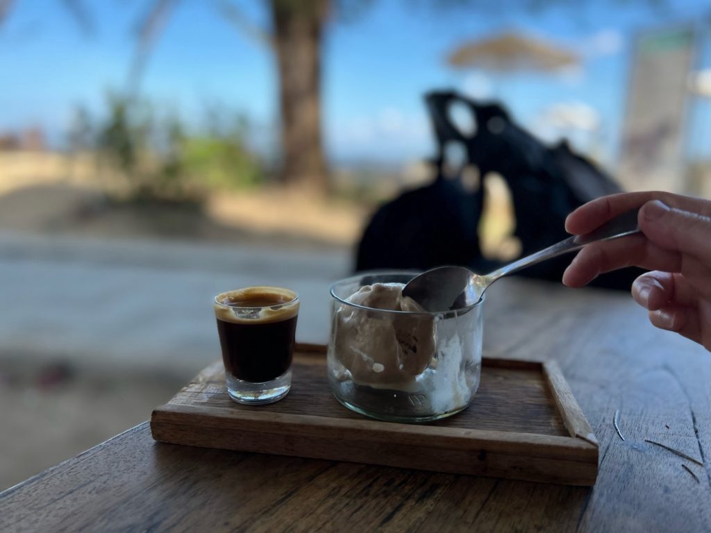 Photo of a coffee affogato in front of a tropical beach.